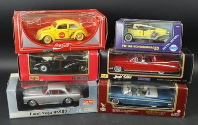 four model cars are in boxes on a black surface