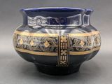 a blue and gold vase sitting on a table