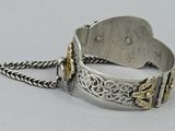 silver and gold bracelet with a tag on it on a chain