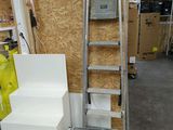 une échelle posée à côté de quelques cartons dans une pièce