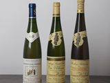 trois bouteilles de vin sont alignées sur une table en bois