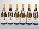 six bouteilles de vin blanc sont alignées sur une table