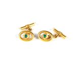 a pair of gold and emerald cufflinks on a white background