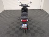 a motor scooter parked in a room with a checkered floor