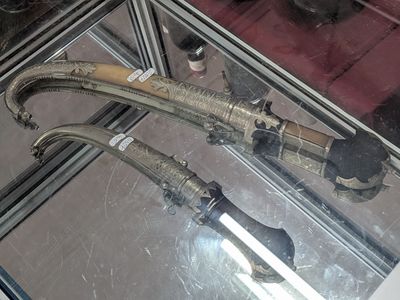a glass display case with a pair of old knives on it