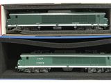deux trains miniatures posés dans une boîte sur une surface blanche