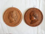 two plaques of a man and a woman on a white cloth
