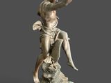 statue of a man sitting on top of a rock with his arm raised