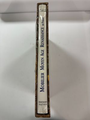 un vieux livre posé sur une table blanche