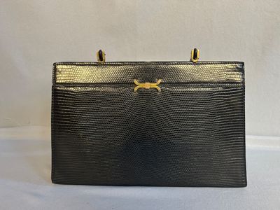 un sac à main en peau de lézard noir avec des finitions dorées