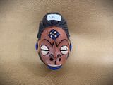 a ceramic mask on a leather surface