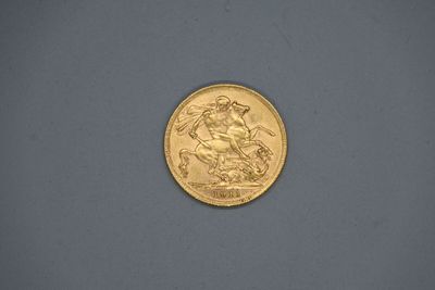 gros plan d'une pièce d'or sur une surface grise