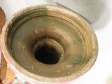 a large metal vase with a hole in the middle