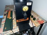 a coffee machine sitting on a table with a clock on it