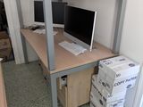 a computer desk with two monitors on it and boxes on the floor