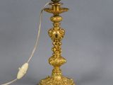 an antique brass table lamp with a cord plugged to it