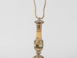 a gold and green lamp on a white background with a cord