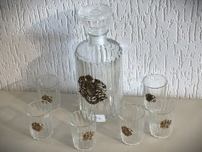 quatre verres à shot et une carafe posés sur une table