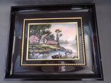 framed picture of a painting of a cottage by a river