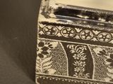 a small wooden box with a white and black design on it