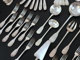 a lot of silver spoons and forks on the table