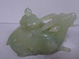 a green jade sculpture of a man riding a turtle