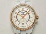 une montre blanche et dorée posée sur une surface blanche