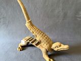 une image représentant un petit lézard en bois sur fond gris