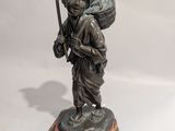 une statue représentant un homme avec un sac sur le dos