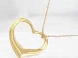 un pendentif en forme de cœur en or avec une chaîne, sur fond blanc