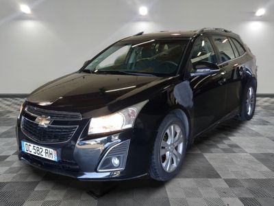 La Chevrolet Cruz noire est garée sur un sol en carrelage à damier.
