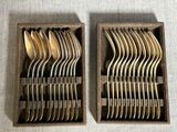 deux boîtes contenant des fourchettes et des cuillères, posées sur une table