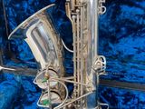 a silver saxophone sitting in a blue velvet case