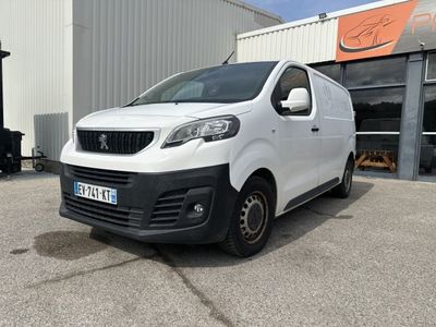 une camionnette blanche garée devant un bâtiment dans un parking