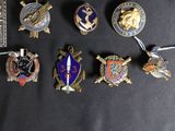 several different military badges are displayed on a black surface