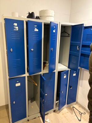plusieurs casiers bleus dans une pièce, avec un homme debout à côté d'eux