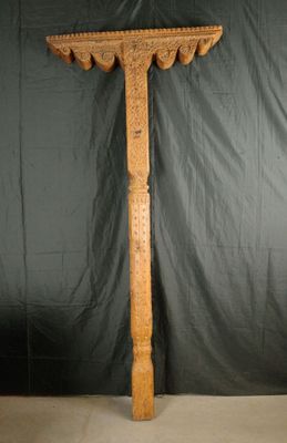 un grand poteau en bois orné de sculptures, sur fond noir