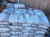 une pile de sacs de ciment près d'une clôture