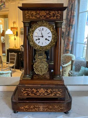 a clock that is sitting on a table in front of a mirror