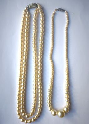 deux colliers de perles posés sur un fond blanc, avec un fermoir en argent