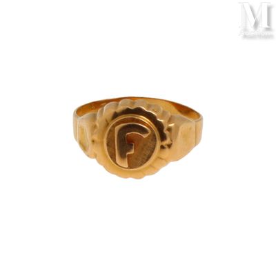 un gros plan d'une bague en or sur laquelle figure la lettre « g »