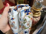 a woman that is holding two vases in her hand