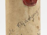 a bottle of wine with a wax stamp on it