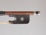 un archet de violon muni d'un manche en bois d'où sort une tige en bois