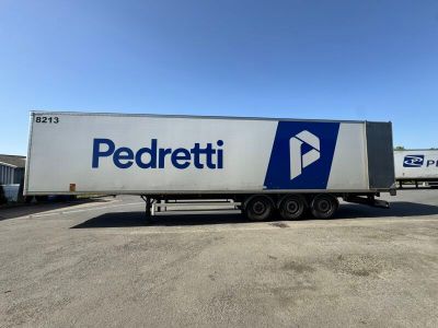 a white semi truck parked in a parking lot next to a building