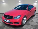 Une Mercedes CLA rouge est garée dans un garage.