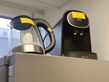 a coffee maker on top of a refrigerator in a kitchen