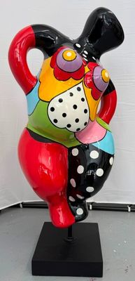une statue représentant une femme tenant un chat, posée sur un socle noir