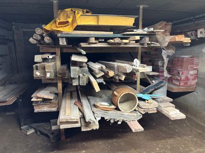 un tas de bois dans un garage, surmonté d'un seau jaune