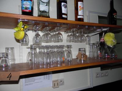 a wooden shelf with wine glasses and bottles on it